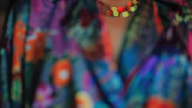 Medium shot of a model showcasing bold vibrant streetwear inspired by global Fashion Week trends with the background softly blurred to highlight intricate garment details.