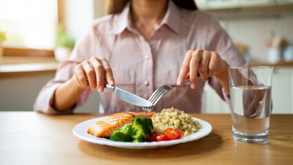 Naklejka premium Woman enjoying a healthy balanced meal of grilled salmon, quinoa, and broccoli with fresh vegetables, promoting a clean eating, diet, and nutritious lifestyle for wellness