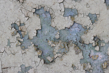 Peeling paint on the wall. Old concrete wall with cracked flaking paint. Weathered rough painted...