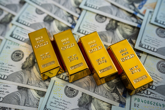 Gold bars on dollar bills background – Wealth, investment, finance and precious metal concept