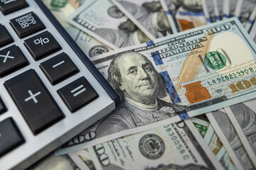 US currency and a calculator, representing budgeting and economic calculations.