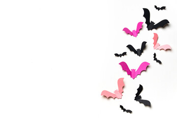 Pink and black paper bats on white background.