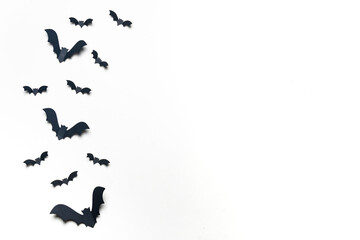 Black paper bats on white background.