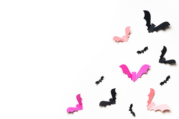 Pink and black paper bats on white background.