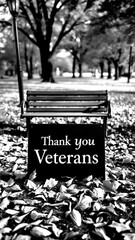 Sign honoring veterans placed on a bench surrounded by autumn leaves in a park