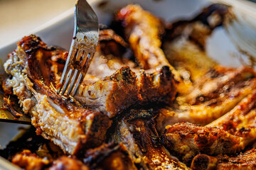 Juicy, slow-cooked BBQ ribs glistening with savory sauce, a fork piercing tender meat, promising a mouthwatering feast for any occasion, perfect for restaurant menus or food blogs.