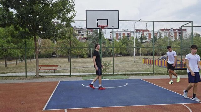 Friends enjoy a lively game of basketball on an outdoor court, showcasing teamwork and active lifestyle. They practice shots and dribbling, embodying friendship, sports, and healthy recreation. - Powered by Adobe