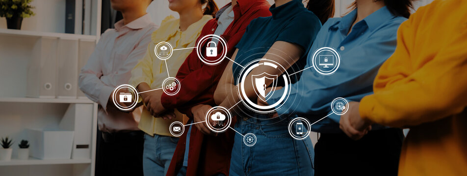 A group of diverse professionals stands confidently in a modern office, showcasing teamwork with cybersecurity icons overlay, emphasizing collaboration and technological innovation. Trope - Powered by Adobe
