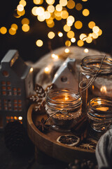 Creative handmade christmas home decor decorations: simple glass jars with aroma candles decorated with a ribbon, cinnamon, anise, dry orange. Cozy atmospheric composition for holiday mood creation