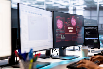 System administrator in server farm fighting hacker managing to pass firewall and stealing data. Worker receiving critical error notification on PC display in data center workspace