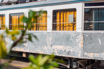 Obraz premium Old tram of opicina tram system is being renovated on the siding tracks of Opicina train station, visible orange curtains and sanded down body of a tram