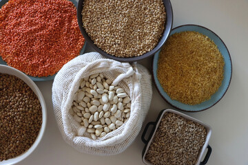 Bowls and bags full of various healthy grains and legumes. Top view.