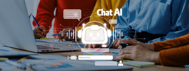 Modern Workspace Featuring Men and Women Engaging with AI Technology and Chatbot Interface on Laptop with Colorful Papers and Graphical Elements Trope.