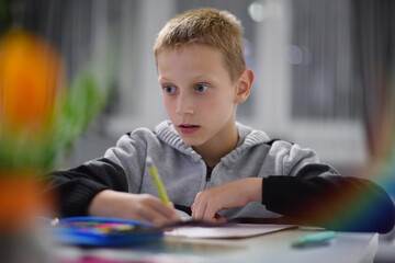 Preteen boy concentrating on schoolwork at home