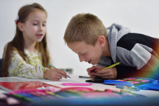 Brother and sister doing homework together at home
