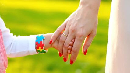 Mother and child holding hands outdoors on a sunny day. A heartwarming shot of maternal love and support. Autism awareness, parental guidance, childhood development. - Powered by Adobe