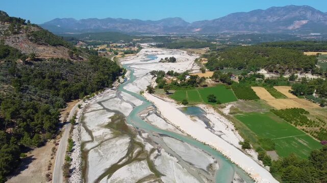 aerial perspective captures the majestic Saklikent National Park in Turkey, showcasing the winding, turquoise waters of the Esen &Ccedil;ay Xanthos River flowing through the dramatic canyon landscape.