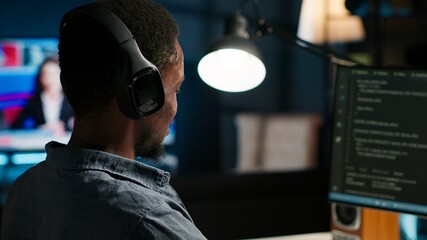 Male developer entering binary data on terminal panel while writing html code. Software engineer working on troubleshooting with programming language, internet and server security. Camera B.