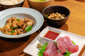 Japanese dinner with tuna sashimi, stir-fried chicken and vegetables, simmered beans, rice and miso soup

