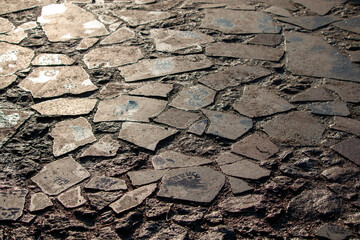 Close-up of textured ground with broken ancient pottery pieces and rough earth.