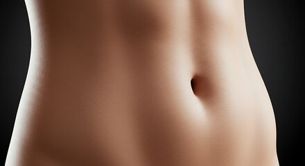 Close up of a toned abdomen with smooth skin against a dark background