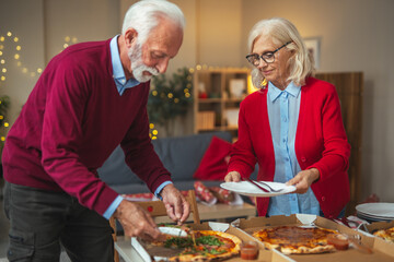 Senior couple sharing pizza dinner celebrating togetherness at home