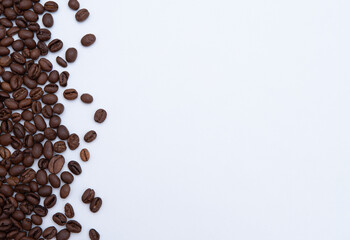 A mixture of roasted coffee beans scattered on a white background