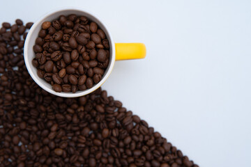 A cup of coffee with a pile of coffee beans next to it. The coffee beans are spread out in a pattern, creating a sense of depth and texture. Concept of warmth and comfort