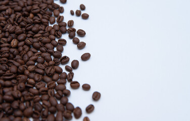 Macro of roasted coffee scattered on a white background