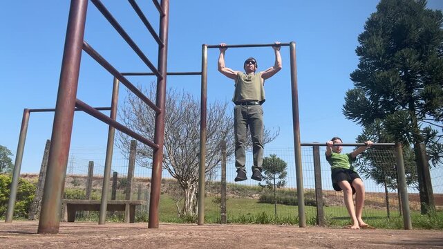 homem faz exerc&iacute;cios f&iacute;sicos em barra ao ar livre 
