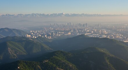 Scenic aerial view of mountains and cityscape under a hazy sky