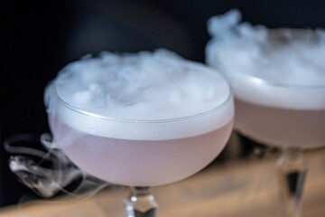 Mysterious cocktails with dry ice creating foggy aura, showcasing elegant drinks in stylish...