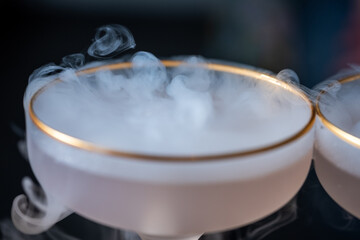 Mysterious cocktails in elegant glasses with foggy dry ice, creating an enchanting aura for a party...