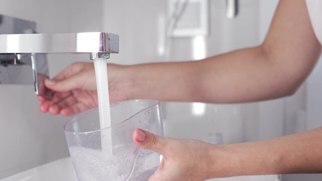 A portable water flosser for oral care in a bright home bathroom. Concept: hygiene and dental care for a healthy smile.