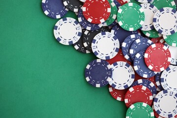 Casino gaming background with stacks of betting chips of different colors on green gaming mat