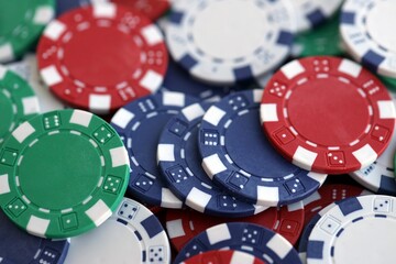 Close up of a group of casino chips on a green mat for poker or dice games indoors
