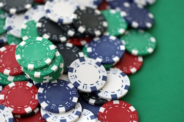 Close up of a group of casino chips on a green mat for poker or dice games indoors