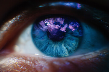 Extreme close up human blue eye reflects glowing earth map