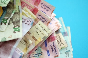 Ukrainian money bills on light blue paper background