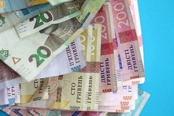 Ukrainian money bills on light blue paper background