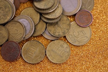 Big amount of euro coins on golden glitter background