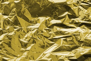 Golden crumpled foil texture on flat surface