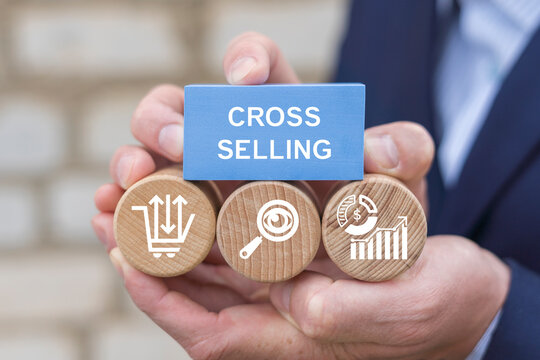 Marketer holding blocks with icons sees the inscription CROSS SELLING. Cross selling business strategy and analytics concept. Сross-selling marketing tactics.