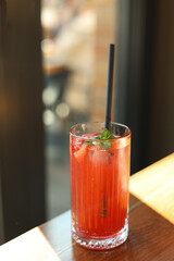 Glass of strawberry lemonade with mint leaves.