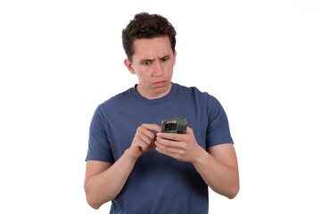 Man in a blue T-shirt looking alarmed at something on his cell phone
