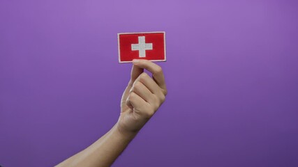 Man holding swiss flag embroidery against a vibrant purple background showcasing national pride and customization potential.