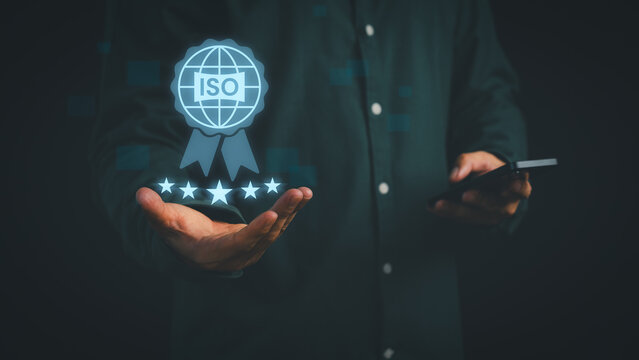 Businessman holding digital ISO certification icon with five-star rating, symbolizing international standard, quality assurance, compliance, trust, and business excellence in professional management.