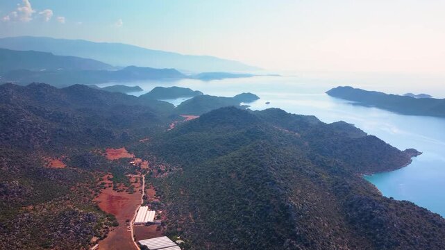 aerial perspective showcasing the ancient ruins of Simena Kalesi Kalek&ouml;y Castle overlooking the stunning turquoise waters and lush green hills of the Kekova region in Antalya, Turkey.
