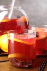 Tasty punch and fruits on wooden table, closeup. Refreshing drink