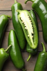 Fresh jalapeno peppers on wooden table, top view
